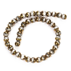 Détail de perles en cristal facetté marron et argent disposées en spirale sur fond blanc