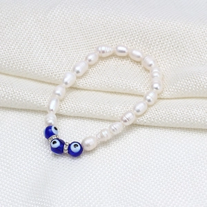 Détail de perles d'eau douce baroques et charmes œil bleu avec entretoises en cristal pavé