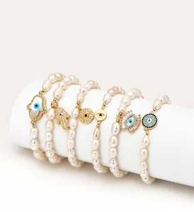 Détail d'un ensemble de cinq bracelets en perles d'eau douce avec main de Hamsa et œil bleu