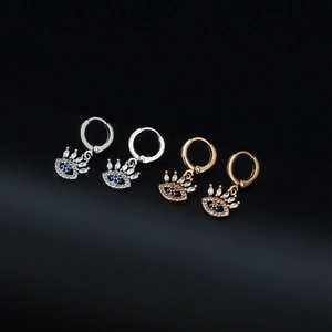 Dettaglio degli orecchini a forma di occhio greco in oro e argento con pietre blu