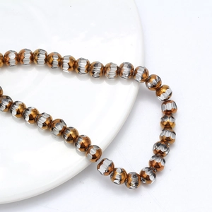 Gros plan de perles métalliques dorées avec texture facettée argentée sur plateau