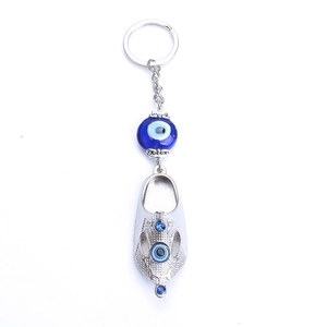 Detail of silver shoe pendant with blue evil eye bead and intricate ethnic engraving
