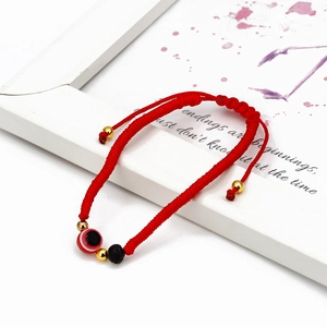 Detail of red woven Evil Eye bracelet with lava stone beads and adjustable slip knot