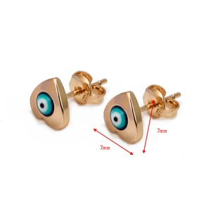 Detailed view of 7mm gold heart earrings featuring blue and white evil eye enamel designs