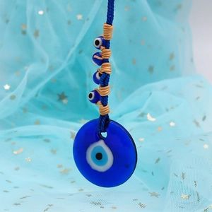 Detailed view of Turkish Evil Eye glass pendant with blue beads and gold thread accents