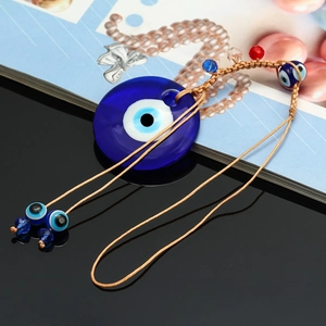 Detail of Turkish evil eye pendant with blue glass bead and braided cord tassels