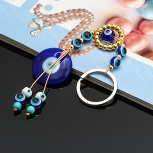 Detailed view of Turkish Evil Eye glass pendant with blue beads and golden accents