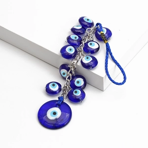 Mediterrane Evil Eye wanddecoratie met blauwe glazen kralen en zilveren ketting op wit