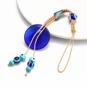 Detailed view of Turkish Evil Eye glass pendant with blue beads on braided nylon cord