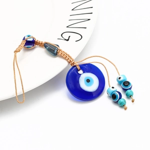 Macro shot of handcrafted Turkish Blue Evil Eye pendant with intricate braided rope cord