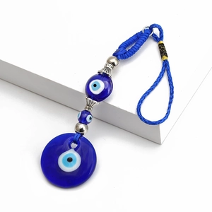 Detail van blauwe glazen Nazar-hanger met nylon touw en zilveren kralenaccenten