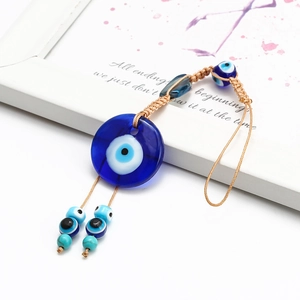 Blue Turkish Nazar Evil Eye pendant hanging ornament with woven cord on white background
