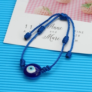 Détail du bracelet œil bleu tressé avec nœud ajustable et breloque en perle de résine