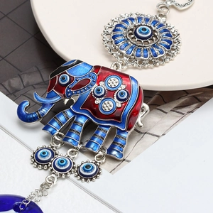 Detail showing an elephant evil eye keychain with blue enamel and glass charm