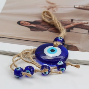Close-up of blue glass Evil Eye pendant with handcrafted hemp rope for home wall decor
