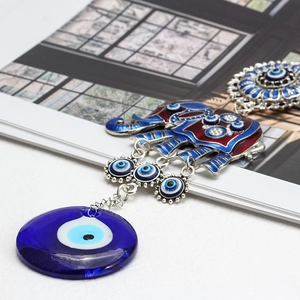 Detailed view of Turkish evil eye elephant pendant with vibrant enamel and blue glass charms