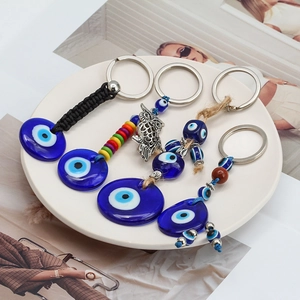 Détails de divers porte-clés Œil Mauvais avec perles de verre bleues sur une assiette