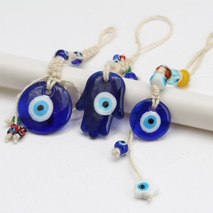 Detail of Turkish Evil Eye glass charms with Hamsa Hand and braided rope for home decor