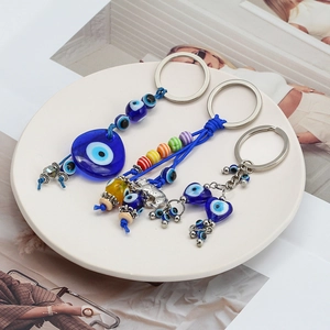 Détail de porte-clés œil bleu avec pendentif éléphant sur un plateau en céramique