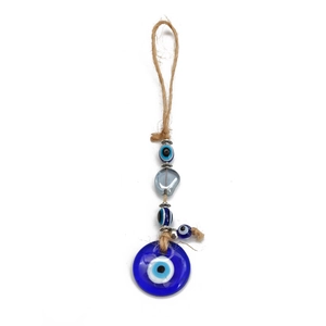 Detail of Turkish blue glass Evil Eye pendant with braided hemp rope and beads for wall hanging