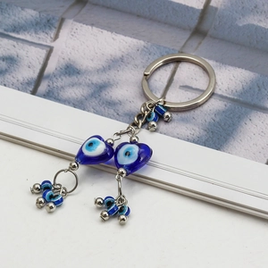 Porte-clés œil bleu avec pendentifs en forme de cœur et perles en verre sur fond blanc