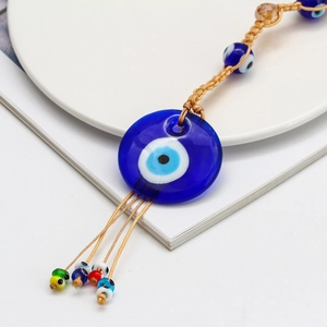 Detailed close-up of blue glass Evil Eye pendant with colorful beads and tassels