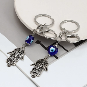 Dettaglio dei portachiavi con ciondoli Mano di Fatima e Occhio del Male in metallo