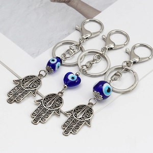 Dettaglio ravvicinato di tre portachiavi a mano di Fatima con perline occhio blu