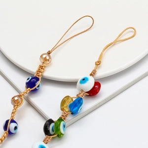 Detailed macro view of bohemian hand-woven evil eye beads and crystal beads phone strap