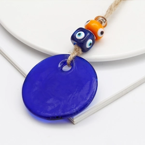 Detailed close-up of blue Turkish evil eye glass pendant with rustic hemp rope