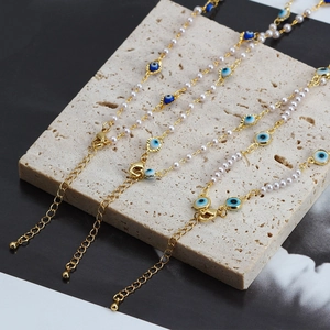 Parure de colliers Evil Eye en perles avec placage or et chaîne réglable sur fond pierre