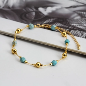 Detailed close-up of blue stone beads and golden chain with lobster clasp and extender