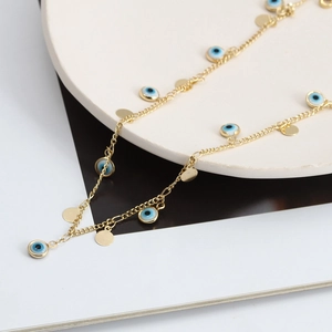 Dettaglio della collana malocchio dorata con perline blu e dischi lucidi a specchio