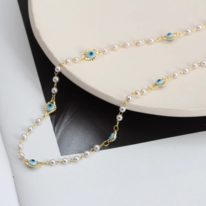 Collier bohème en chaîne dorée avec œil maléfique et perles sur présentoir