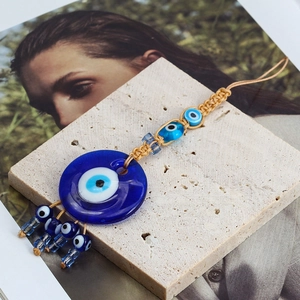 Macro shot of hand-woven Evil Eye lucky charm with blue glass beads and jute rope detail