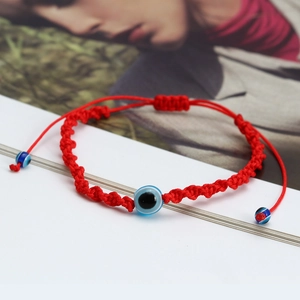 Detail of red braided evil eye bracelet with three blue beads and adjustable knot
