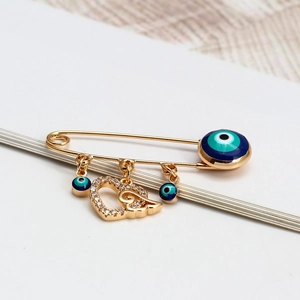 Broche Œil du Diable dorée avec perles Nazar bleues et pendentif cœur en cristal
