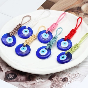 Macro detail of seven colorful hand-woven ropes with Turkish Blue Evil Eye pendants