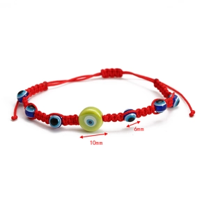 Detail of red woven Evil Eye bracelet with 10mm light green bead and 6mm blue beads