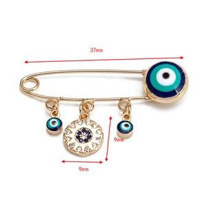 Vue détaillée de la broche épingle à nourrice Evil Eye dorée de 37mm avec breloques soleil