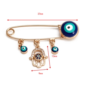 Détails d'une broche œil protecteur avec main de Hamsa et mesures de dimensions sur blanc