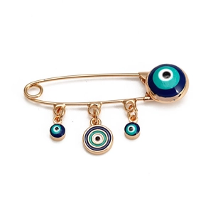 Détail d'une broche épingle à nourrice Evil Eye dorée avec quatre breloques en émail bleu