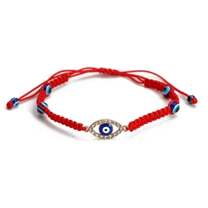 Detail of red braided Evil Eye bracelet with golden rhinestone eye charm and adjustable cord