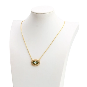 Détail du collier œil maléfique doré avec incrustations de zircons verts et clairs