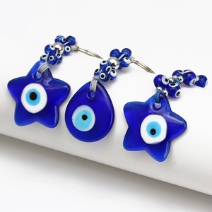 Macro shot of blue glass evil eye charms in star and teardrop shapes with silver beads