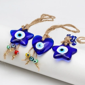 Detail of blue glass Evil Eye charms in star and heart shapes with jute rope and beads