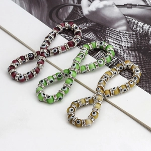 Detailed shot of evil eye beaded bracelets in red, green and yellow with rhinestone spacers