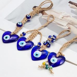Detail of four Evil Eye heart charms with natural jute ropes and blue glass beads