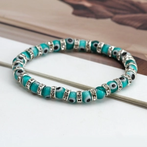 Macro shot of evil eye beads bracelet with crystal-studded silver spacers on white background
