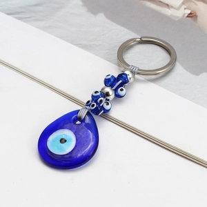 Detailed macro view of the Evil Eye keychain with blue glass teardrop pendant and beads